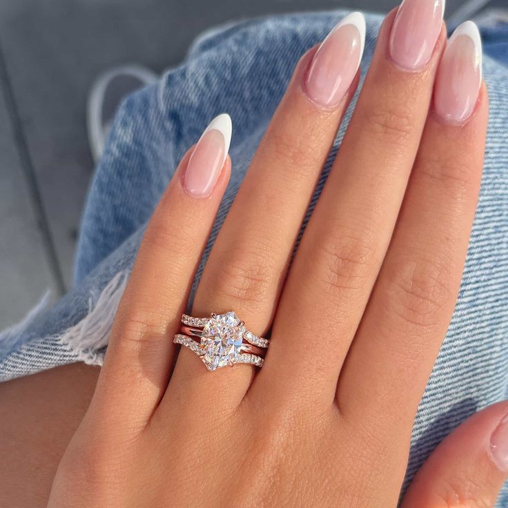 a woman's hand with two engagement rings on it