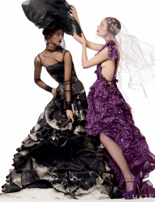 two women dressed in black and purple dresses