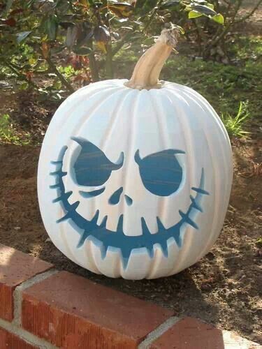 a pumpkin decorated with the face of jack skellingy on top of a brick wall