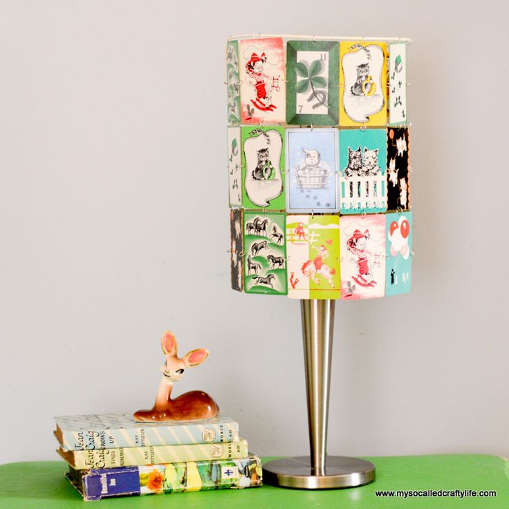 a lamp sitting on top of a green table next to a stack of books and a deer figurine