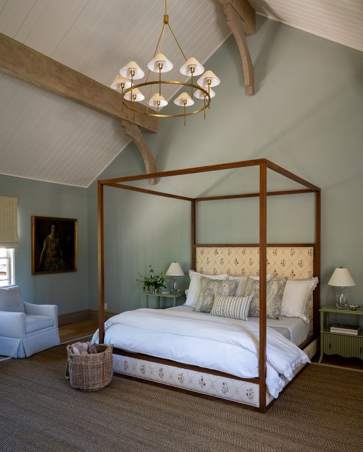 a bedroom with a four poster bed and chandelier hanging from it's ceiling