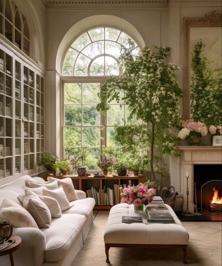 a living room filled with furniture and a fire place in front of a large window