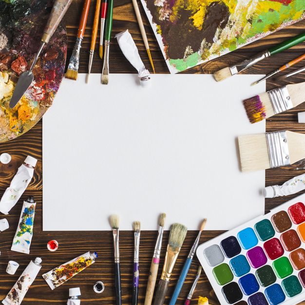 an overhead view of art supplies including watercolors, paintbrushes and paper