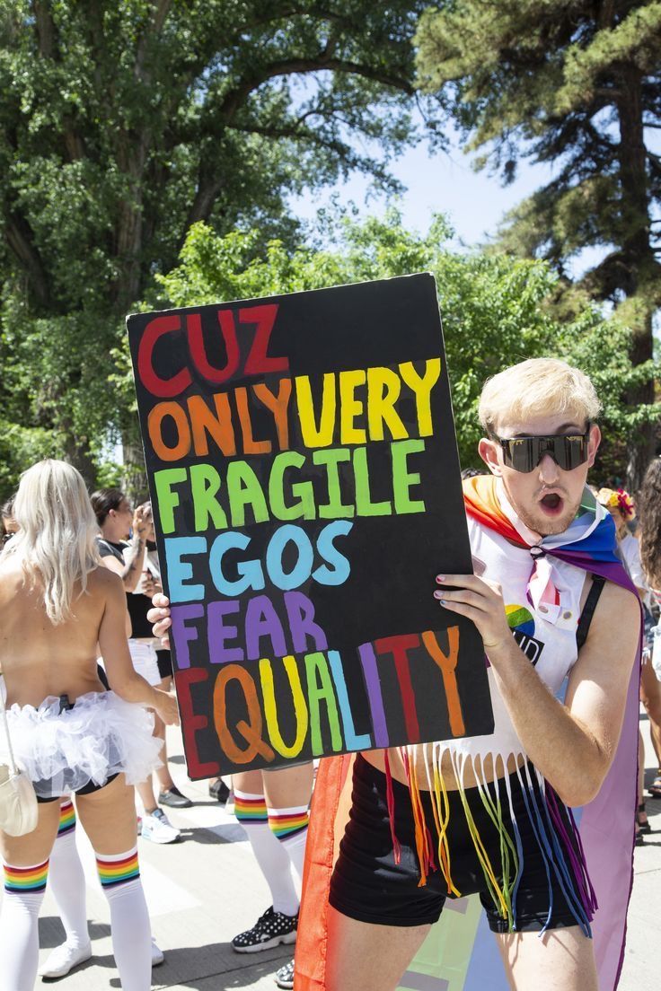 a man holding a sign that says cuz only very fragile eggs for equality