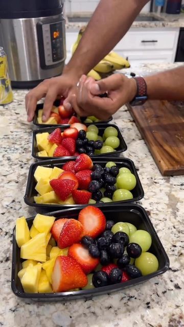 two trays filled with fruit sitting on top of a counter