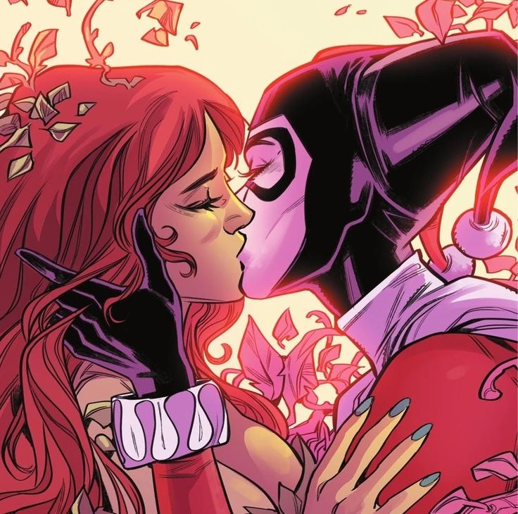 a woman kissing a man with red hair and black mask on his face in front of flowers