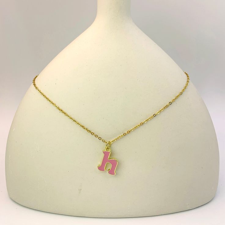 Add a touch of personality and whimsy to your look with our Personalized Pink Initial Necklace. This charming necklace features a custom letter of your choice, crafted with a gold-plated finish and filled with vibrant pink enamel. The delicate chain complements the playful letter, creating a cheerful and eye-catching piece. Perfect for everyday wear or as a gift, this necklace is a delightful way to express your unique style. Personalized Enamel Charm Necklaces For Gifts, Personalized Gold Enamel Charm Necklace, Pink Pendant Charm Necklace, Enamel Initial Pendant Jewelry Gift, Pink Pendant Charm Necklace For Birthday, Personalized Pink Charm Necklace As Gift, Pink Necklace With Adjustable Chain For Her, Trendy Pink Gold Plated Jewelry, Trendy Pink Gold-plated Jewelry