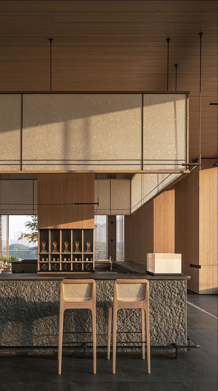 two chairs sitting on top of a counter next to a bar in a room with wooden walls