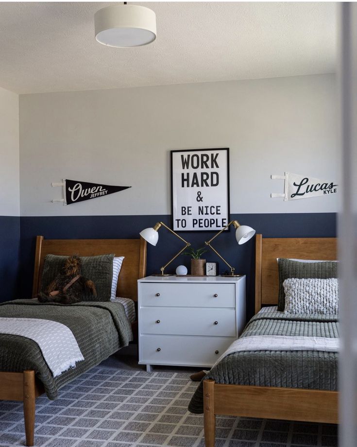 two twin beds in a bedroom with blue walls and white bedding, one has a black and white sign on the wall