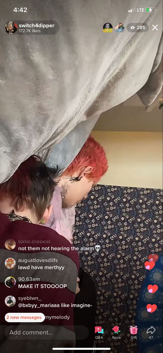 two people sitting under a blanket on top of a couch