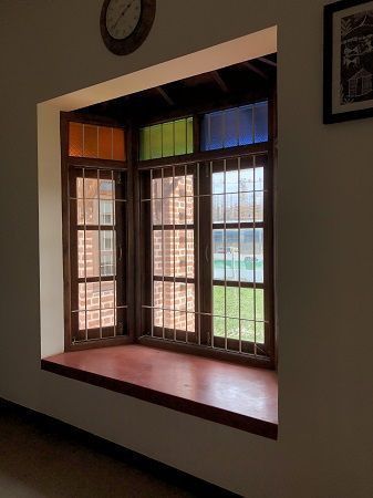 an empty room with three windows and a clock on the wall