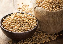 two bags filled with chickpeas sitting on top of a wooden table next to each other