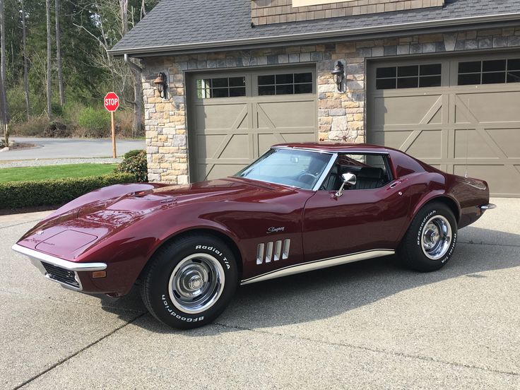 a red sports car parked in front of a garage