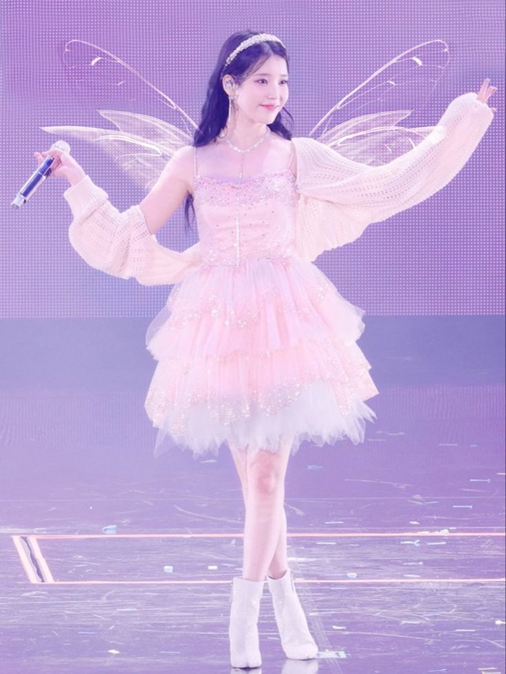 a woman in a fairy costume holding a microphone