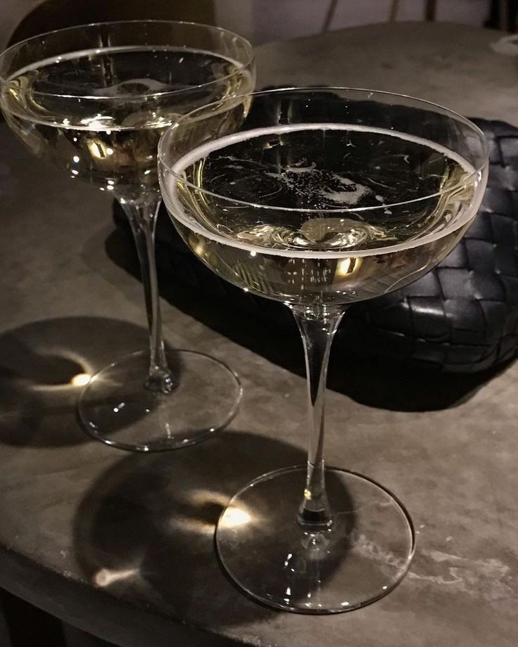 two wine glasses sitting on top of a table