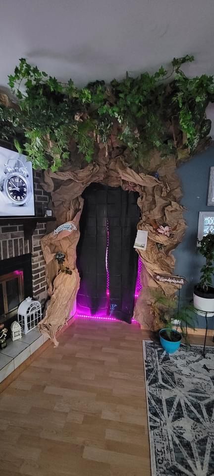 a living room filled with furniture and a fireplace covered in fake trees on top of it