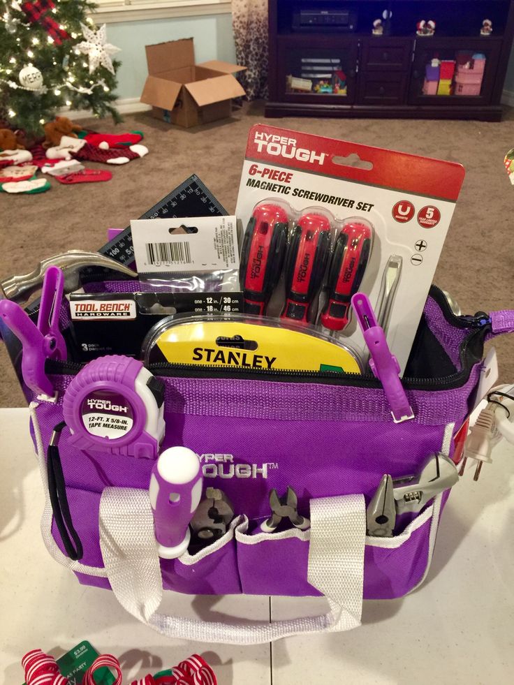 a purple tool bag filled with tools on top of a table next to a christmas tree