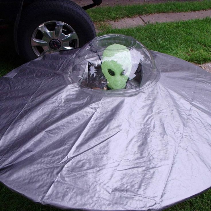 a round table with a cup on it in the middle of some grass near a car