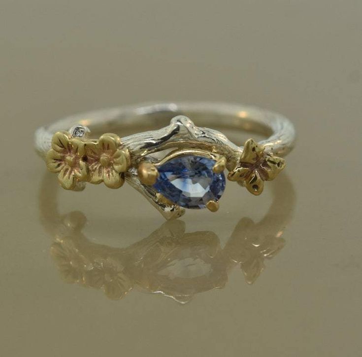 a gold and silver ring with a blue stone