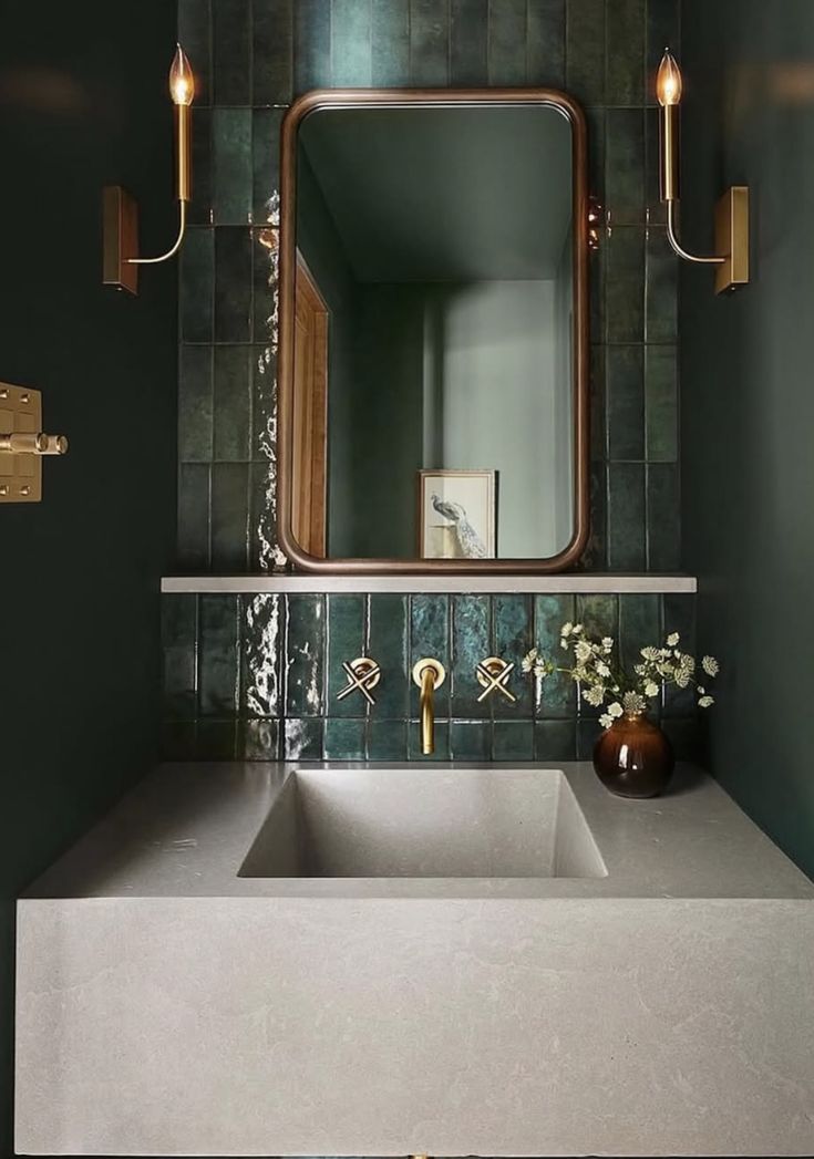 a bathroom sink sitting under a large mirror next to a wall mounted faucet