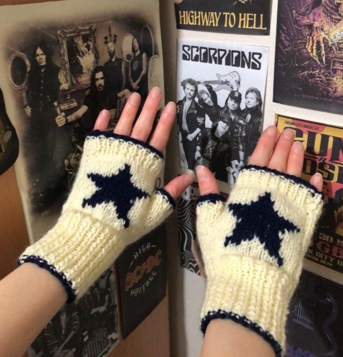 a person wearing knitted gloves with stars on them