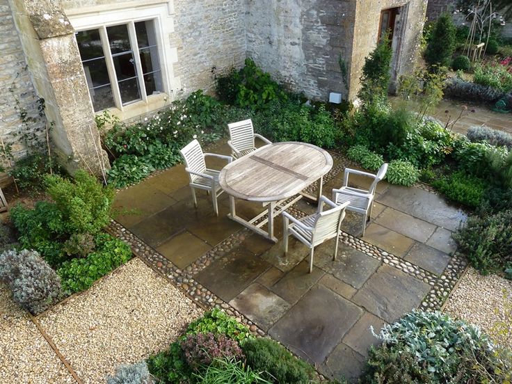 a table and chairs are sitting in the middle of a courtyard area with stone walls