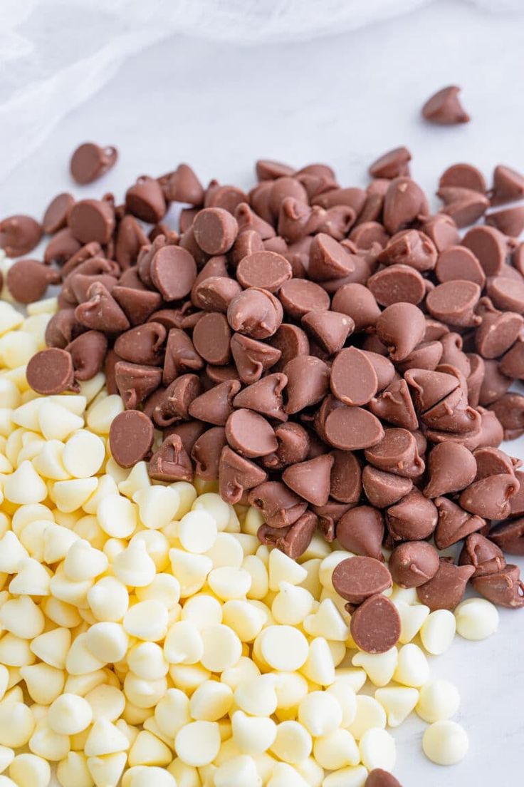 chocolate chips and marshmallows on a white surface