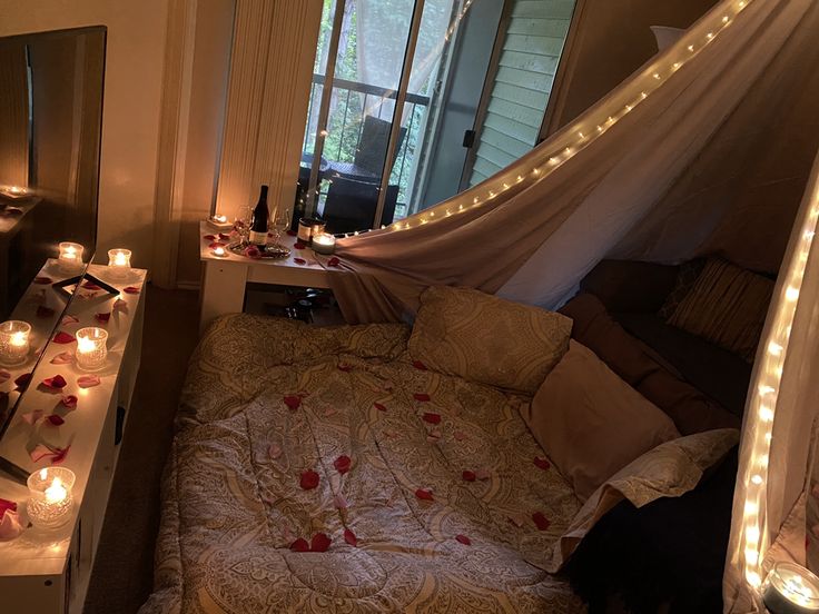 a bedroom decorated with candles and lights for valentine's day or other special occasion