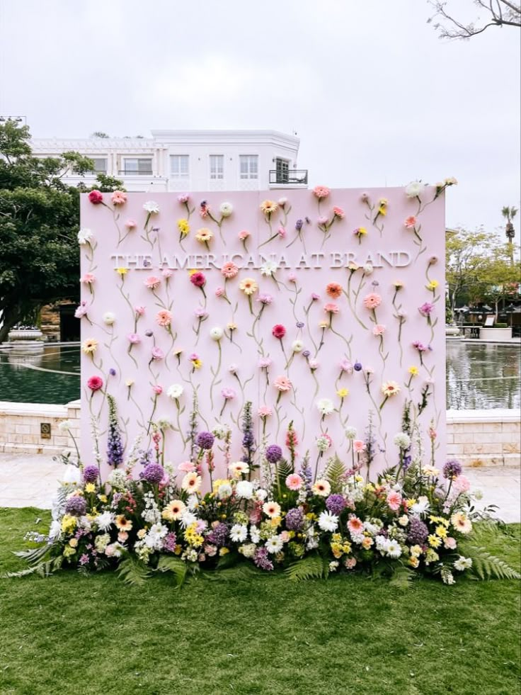 flowers are arranged in front of a pink wall