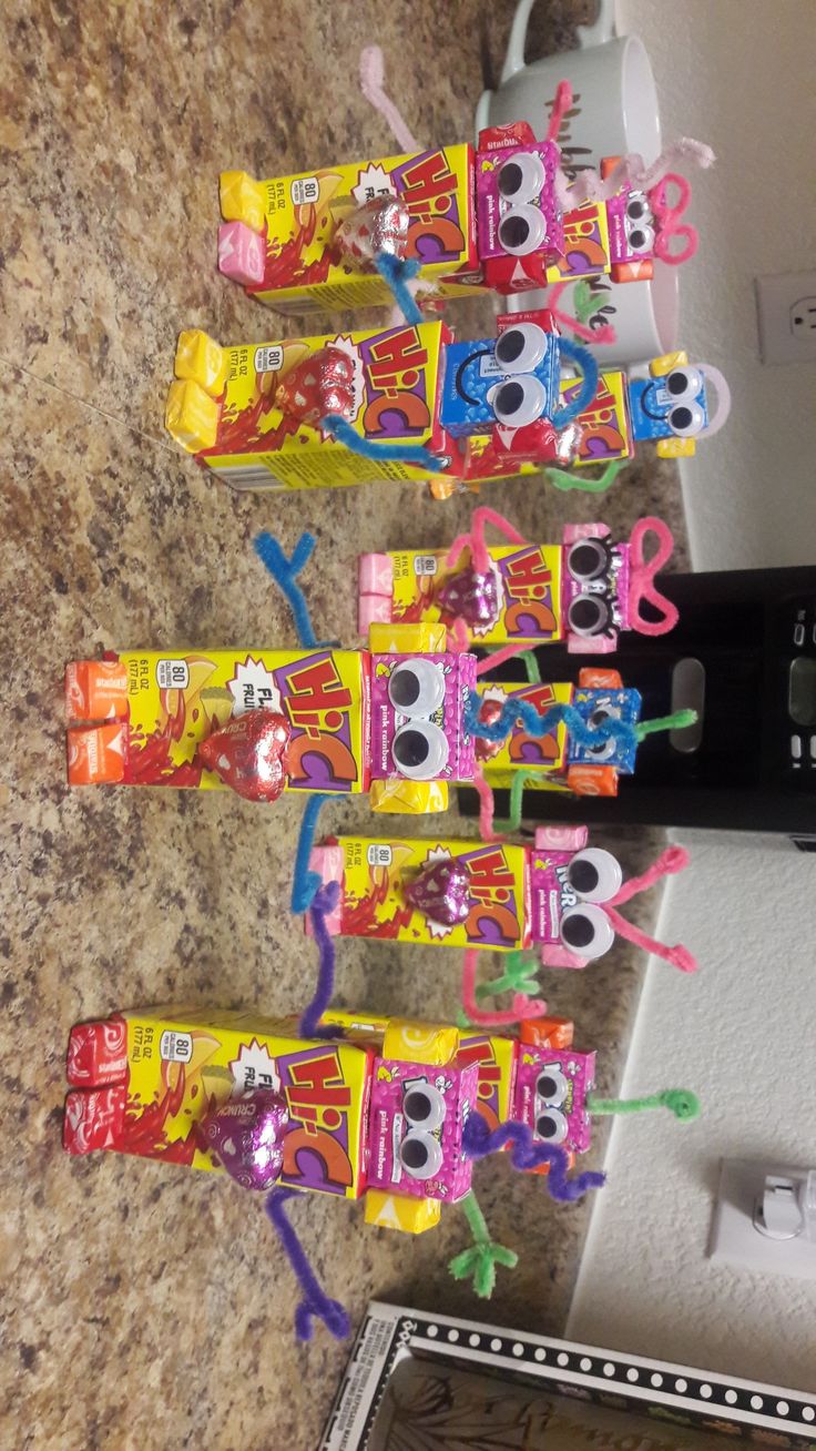 five toy cars are lined up in a row on the counter next to a microwave