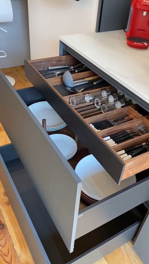 an open drawer in a kitchen with plates and utensils