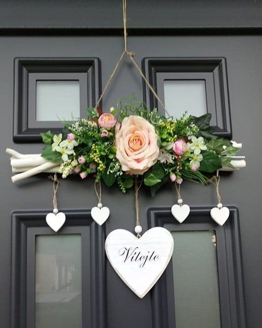 the front door is decorated with flowers and heart shaped hanging signs that spell out'wife '