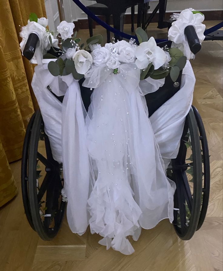 a wheelchair decorated with white flowers and veils