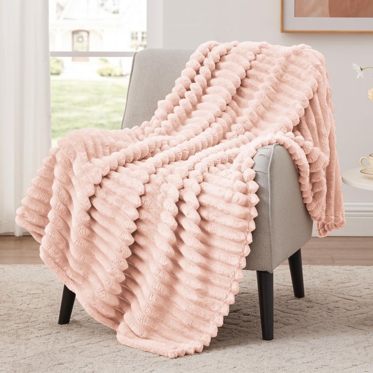 a pink blanket sitting on top of a chair