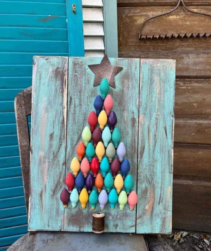 an old piece of wood has been decorated with colorful balls and a star on it