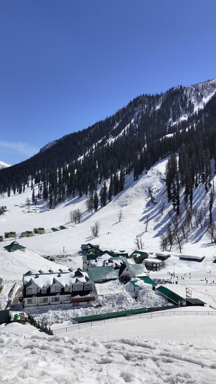 a snow covered mountain with houses and trees