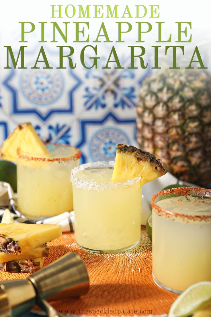 two glasses filled with pineapple margaritas sitting on top of a table next to other drinks