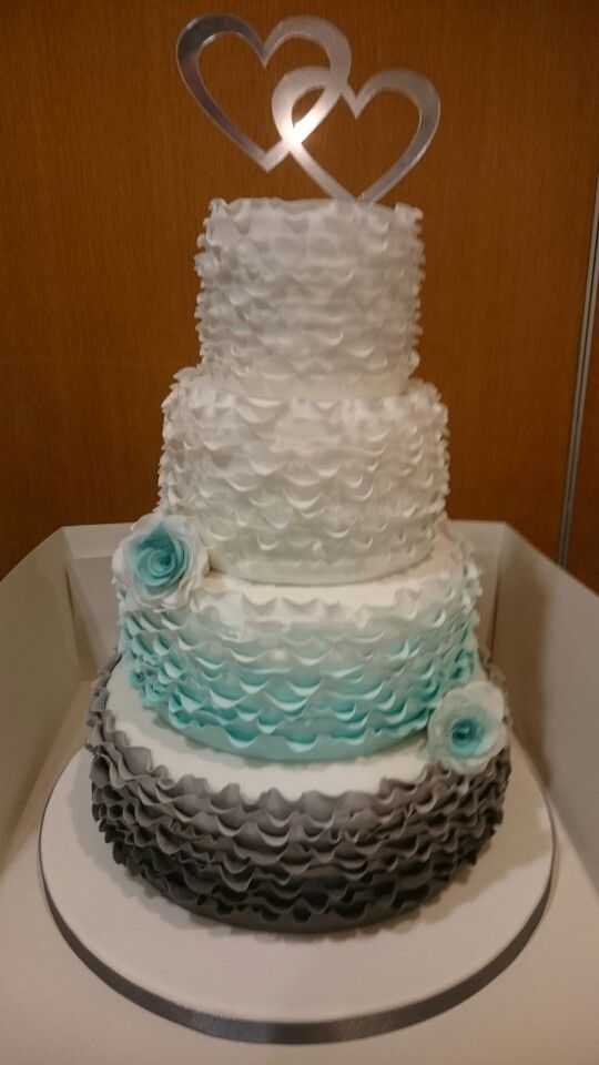 a three tiered cake with two hearts on top