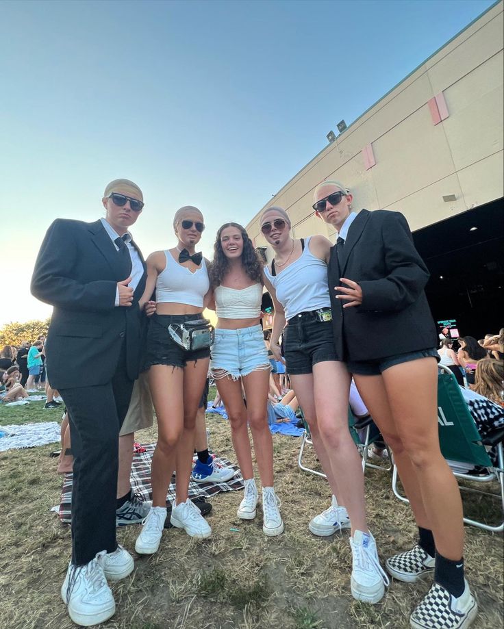 four young people posing for a photo in front of an audience at a music festival