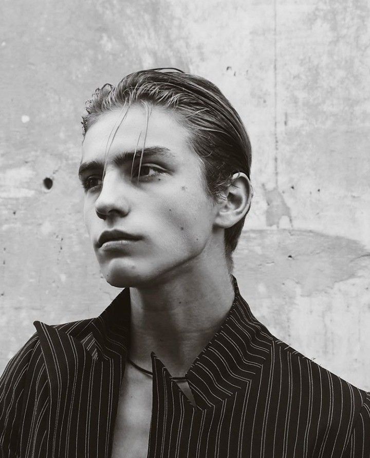 black and white photograph of a young man wearing a striped shirt looking at the camera