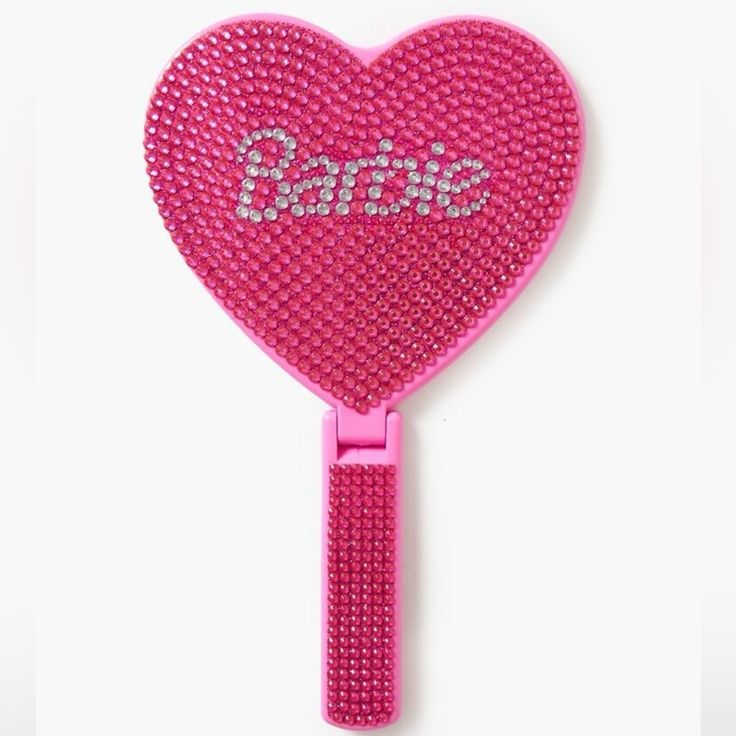 a pink heart shaped comb with the word dance on it