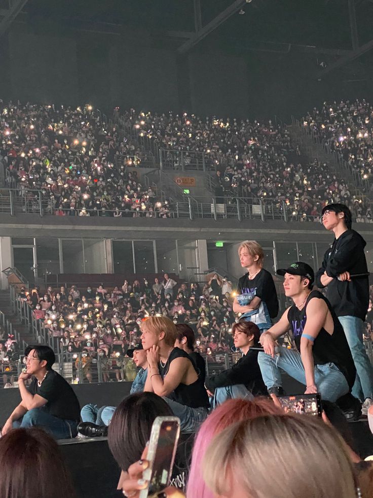 a group of people standing on top of a stage in front of a large crowd