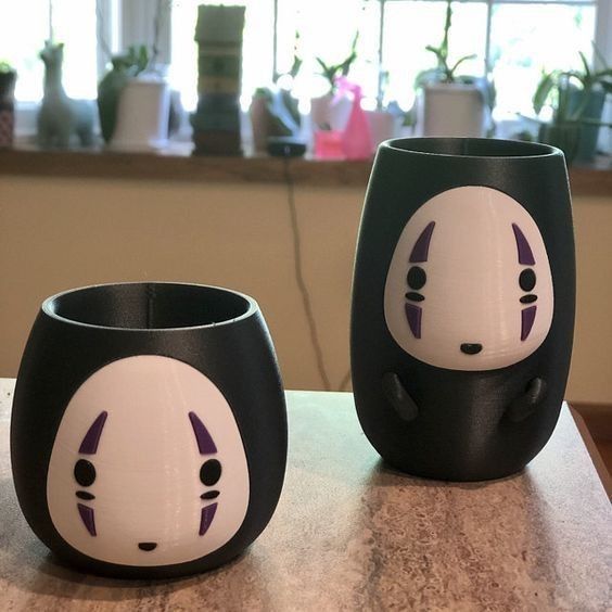 two black and white cups sitting on top of a table