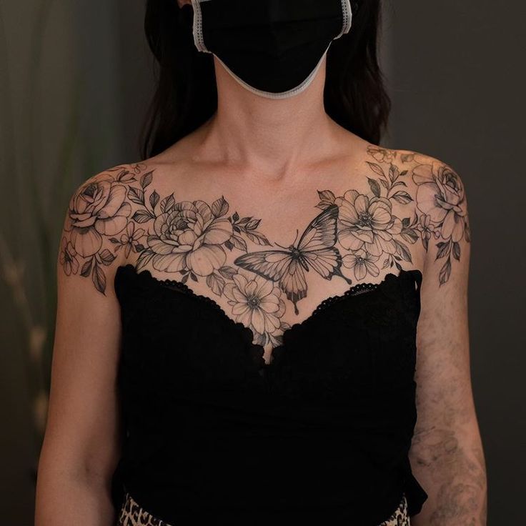 a woman wearing a face mask with flowers and butterflies on her chest is shown in front of the camera