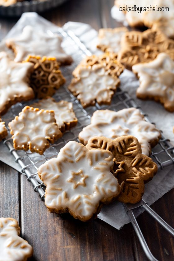 some cookies are on a cooling rack and one is frosted with white icing