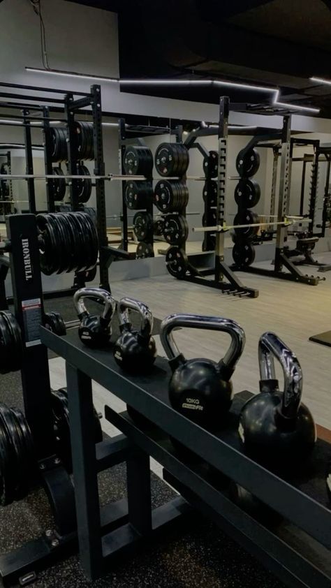 an empty gym with kettles and dumbbells on the rack in front of it