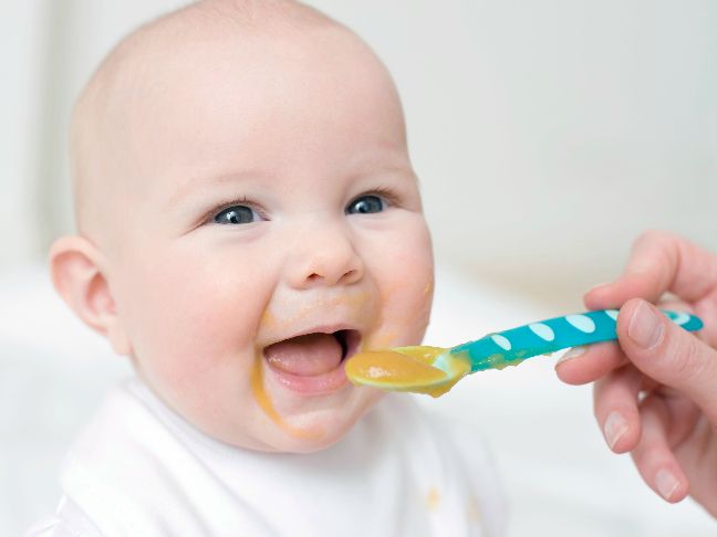 a close up of a baby brushing it's teeth with a blue toothbrush