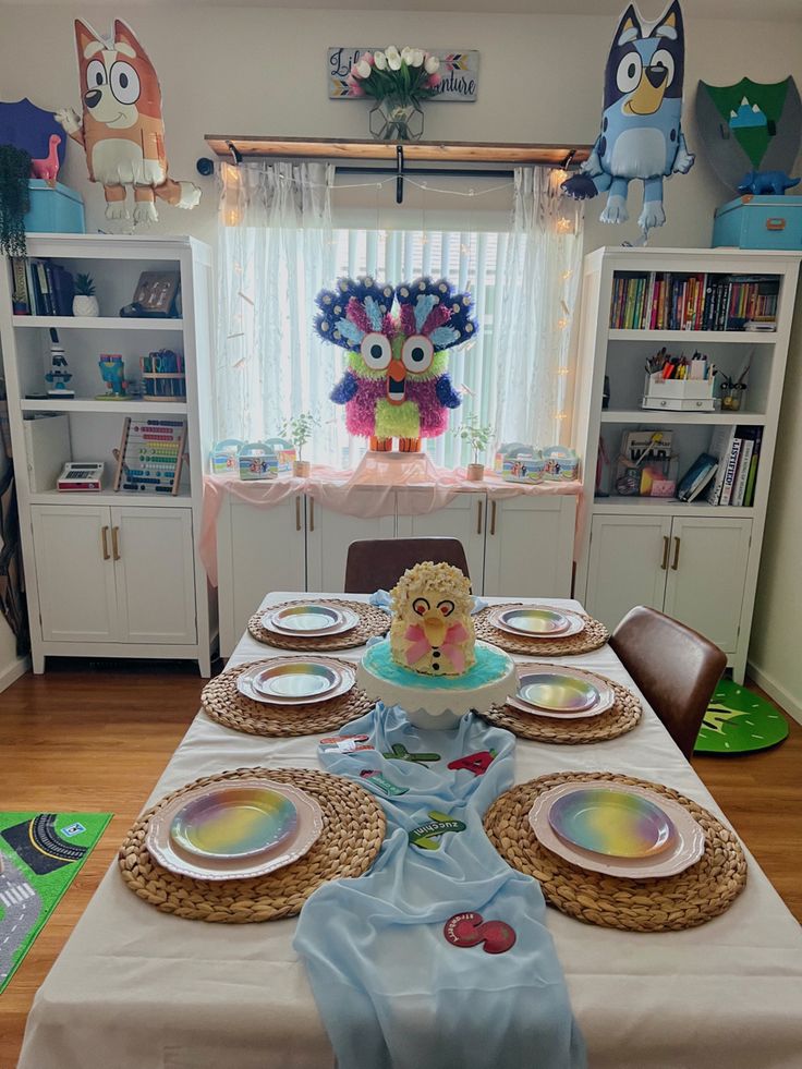 the table is set with plates and place settings for an owl themed birthday party or baby's first birthday