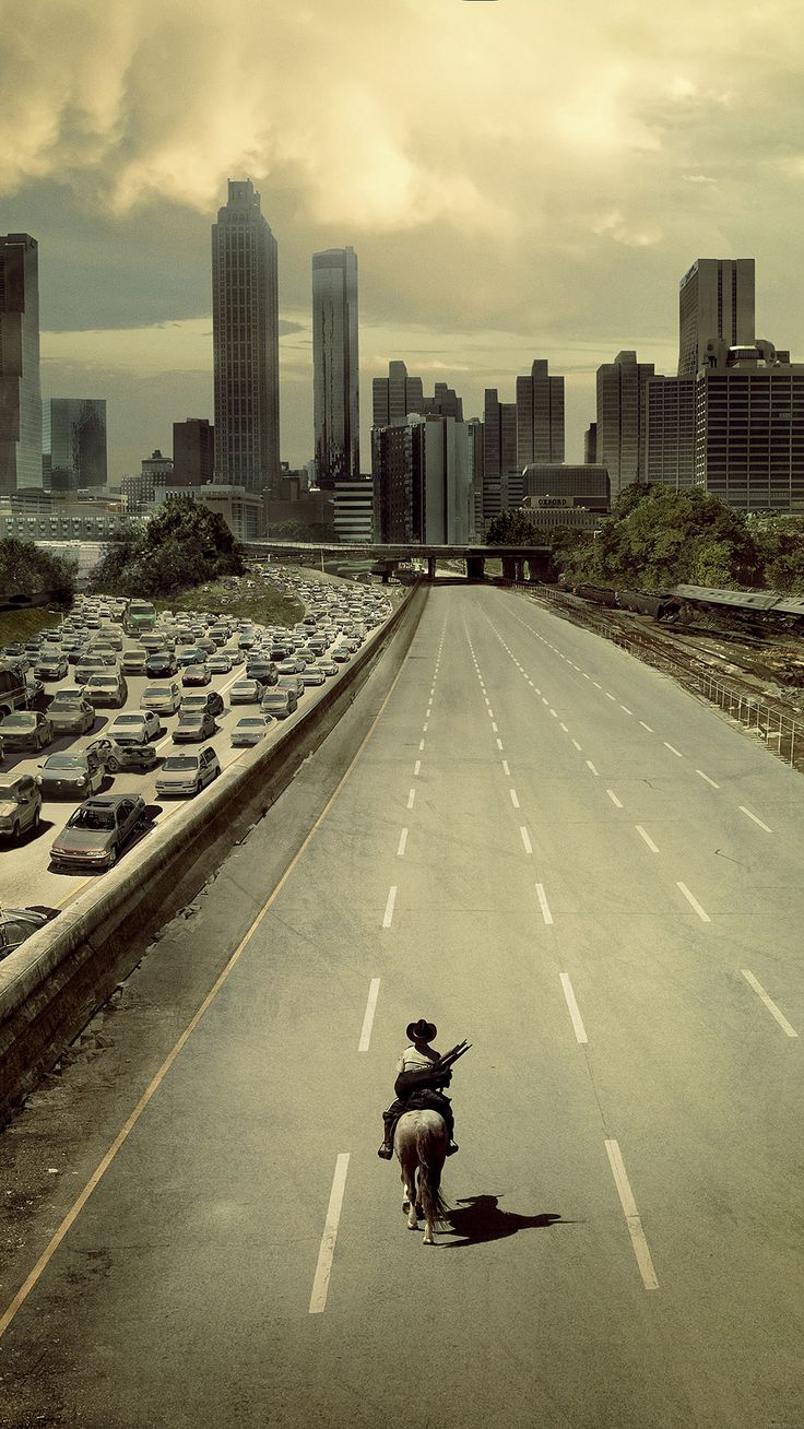 the walking dead poster with an image of a man on a skateboard in front of a large city