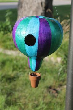 a colorful bird house hanging from a pole